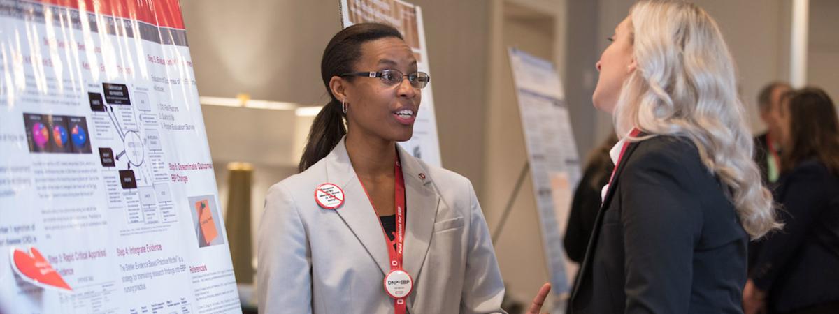 A black nurse at a conference presents her research. 