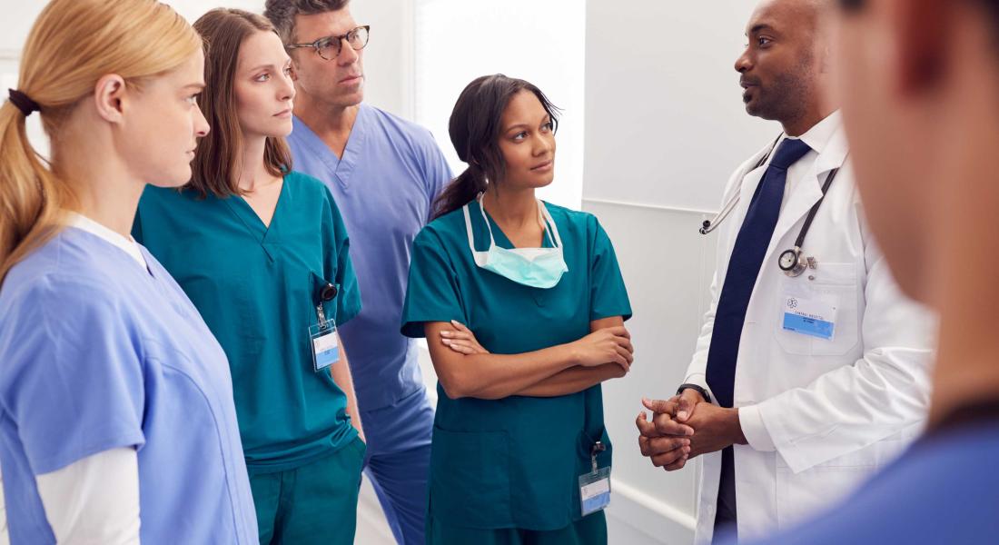 group of healthcare providers talking in hallway